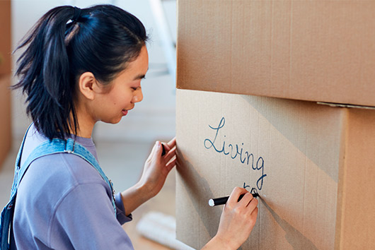 Woman doing moving with boxes and sharpies
