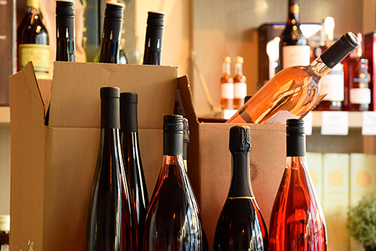 A collection of wine bottles neatly arranged in a box, prepared for relocation in Southern California.