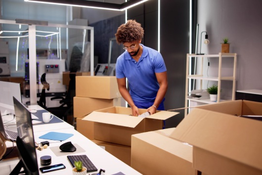 Professional Movers Packing Boxes In Modern Office