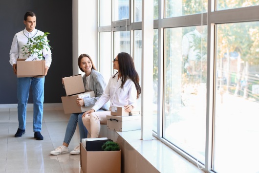 Business people with boxes in office on moving day