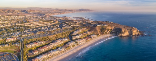 Aerial view of California coast and Dana Point harbor in Orange County on a sunny day.