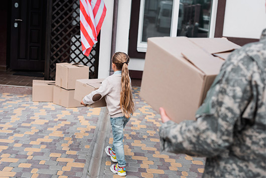 A soldier transporting boxes to a house, illustrating military storage solutions in San Marcos.