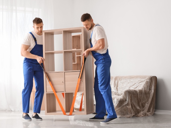 Loaders carrying furniture in flat