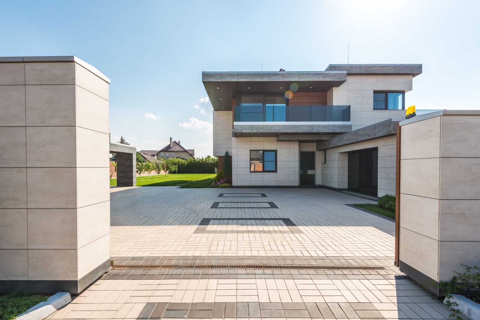 A modern home with an open driveway and landscaped grounds